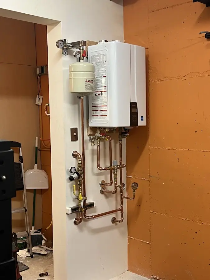 Plumbing technician inspecting water heater connections in Oxford